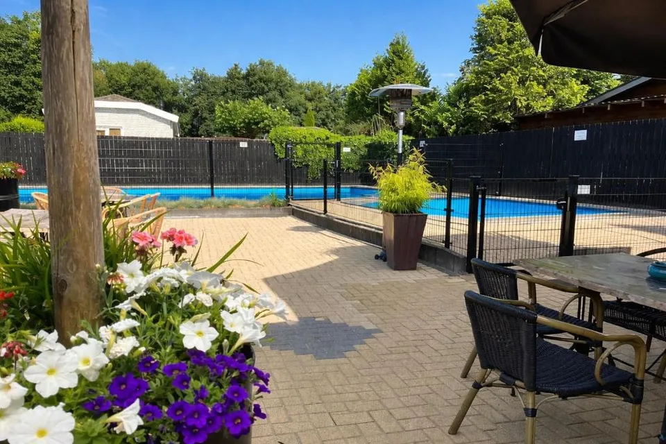 Terras van het grand café met buitenzwembad op Bungalowpark De Kern
